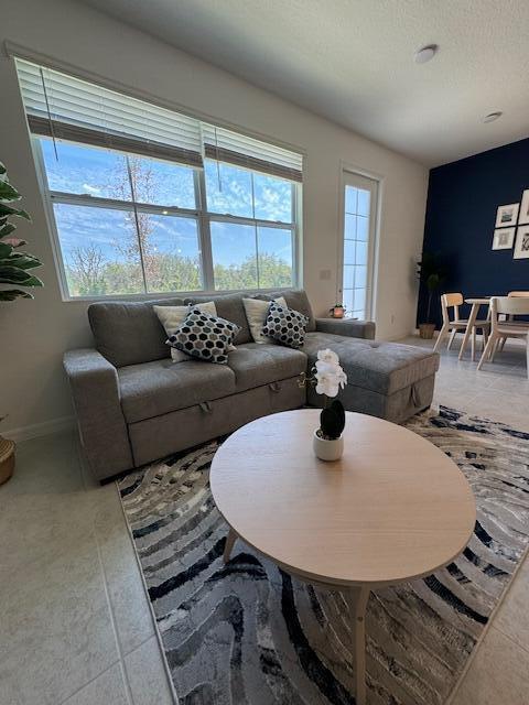 living room with a textured ceiling and tile patterned floors