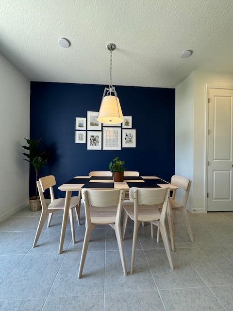 dining room featuring light tile patterned flooring and a textured ceiling