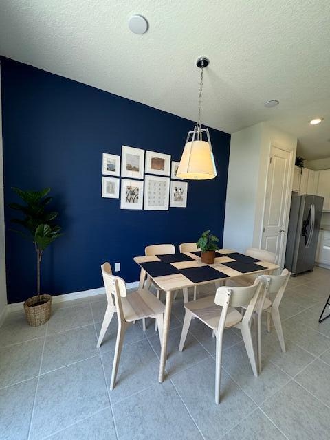 tiled dining area featuring a textured ceiling