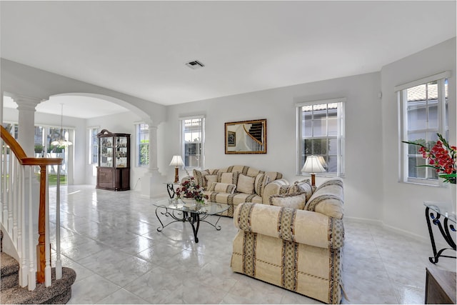 living room featuring a healthy amount of sunlight and ornate columns