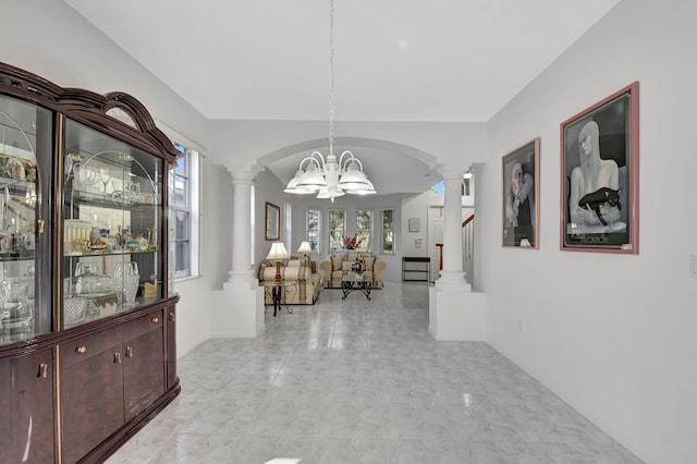 corridor featuring a notable chandelier and ornate columns