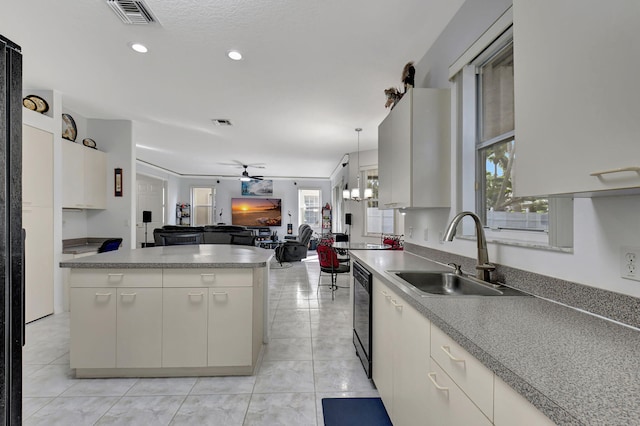 kitchen with dishwasher, a center island, sink, hanging light fixtures, and ceiling fan