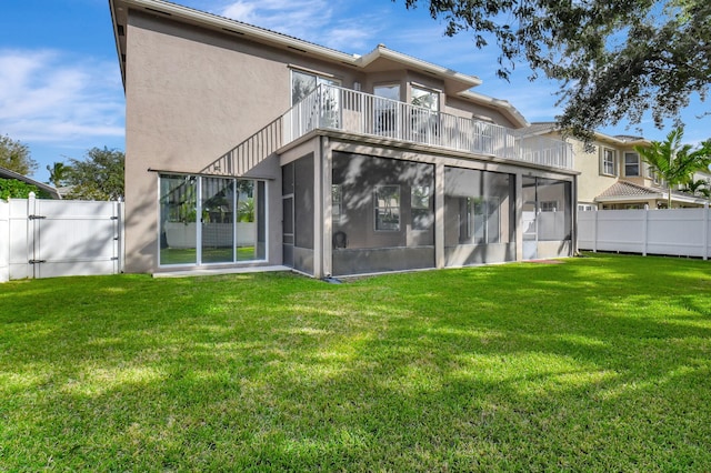 back of house featuring a yard, a balcony, and a sunroom