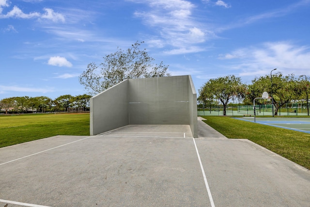 exterior space with basketball hoop and a yard