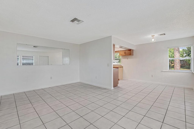 tiled empty room with a textured ceiling