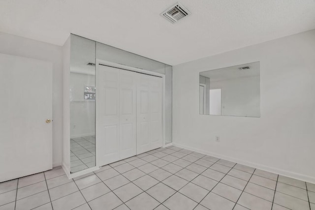 unfurnished bedroom with a closet and light tile patterned floors