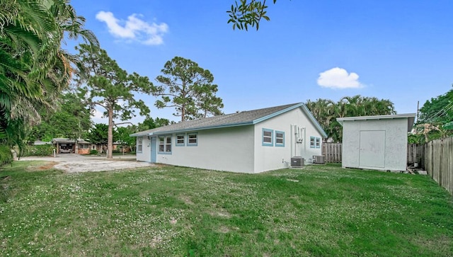 back of property featuring a lawn, a patio area, a shed, and central air condition unit