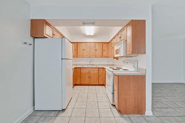 kitchen with light brown cabinetry, sink, light tile patterned flooring, and white appliances