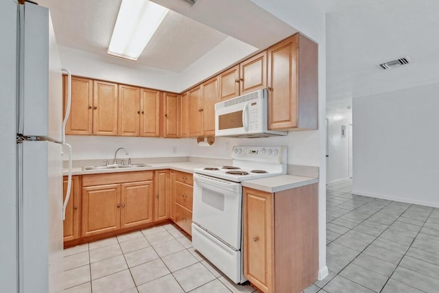 kitchen with light tile patterned flooring, white appliances, and sink