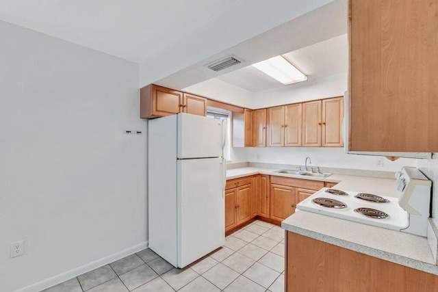 kitchen with light tile patterned floors, white appliances, and sink