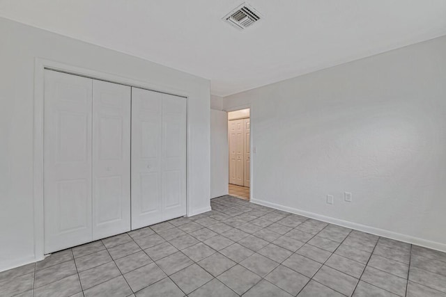 unfurnished bedroom featuring a closet and light tile patterned floors