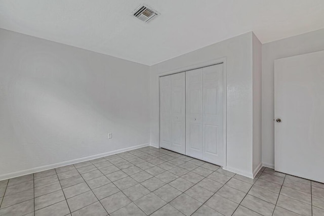 unfurnished bedroom featuring light tile patterned floors and a closet