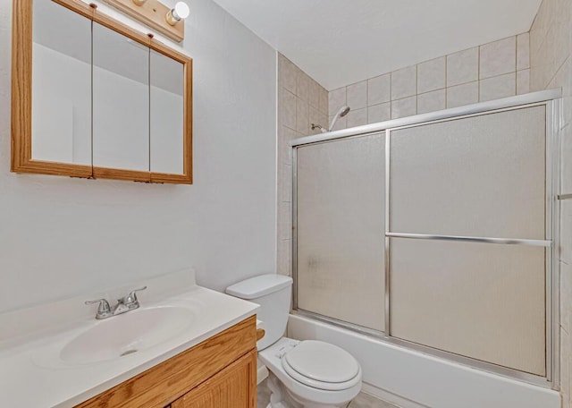 full bathroom featuring vanity, toilet, and bath / shower combo with glass door