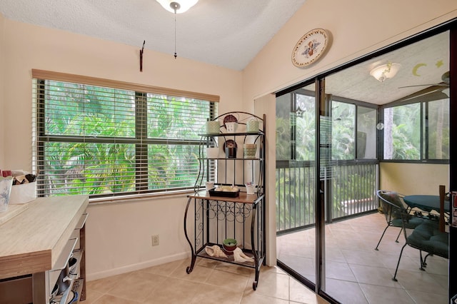 interior space with lofted ceiling, ceiling fan, a textured ceiling, light tile patterned flooring, and a sunroom