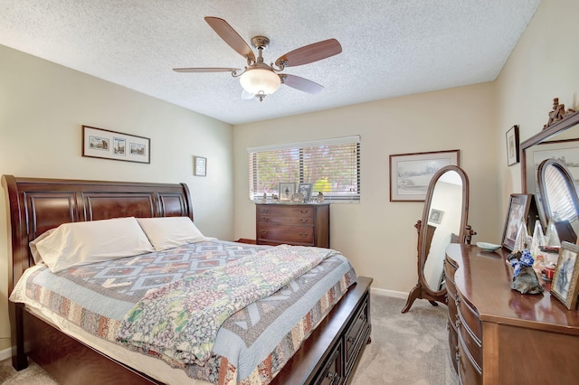 bedroom with a ceiling fan, light colored carpet, a textured ceiling, and baseboards