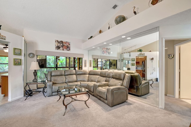 living room featuring a textured ceiling, high vaulted ceiling, visible vents, and light colored carpet