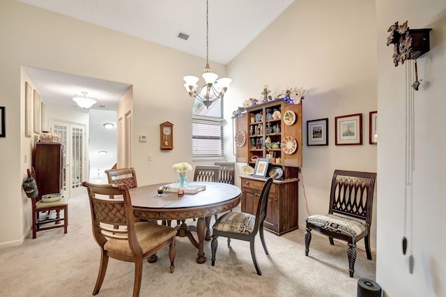 dining room with a notable chandelier, high vaulted ceiling, visible vents, and light colored carpet