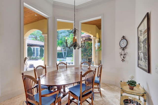 dining room with ornamental molding and a chandelier