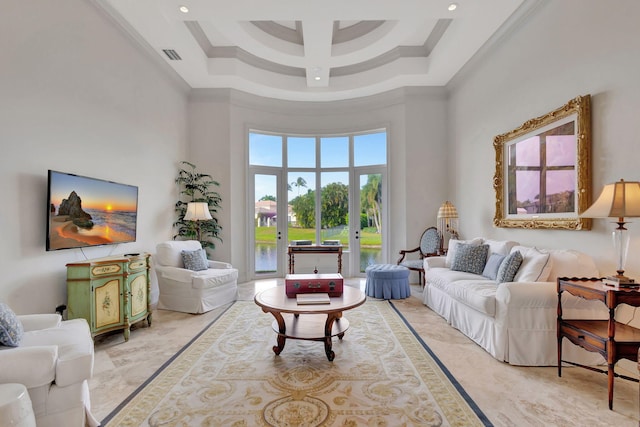 living room with a towering ceiling, a tray ceiling, and crown molding