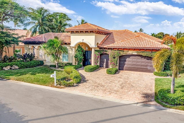 mediterranean / spanish-style house featuring a garage and a front lawn