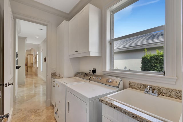 washroom with cabinets, washer and dryer, crown molding, and sink