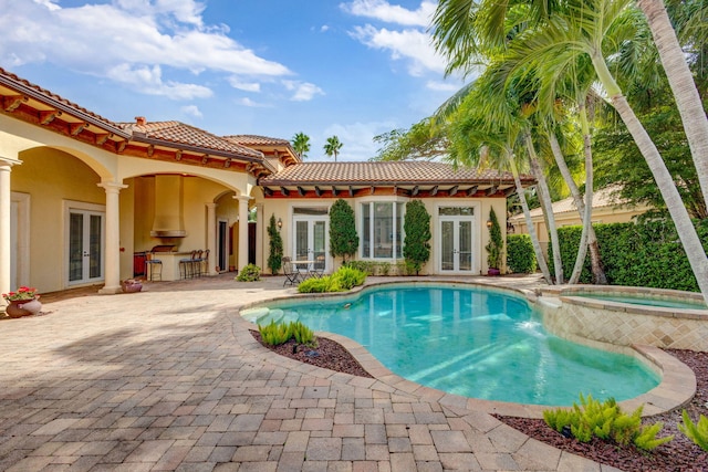 view of pool featuring an in ground hot tub, french doors, and a patio