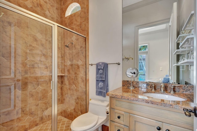 bathroom with vanity, a shower with shower door, and toilet