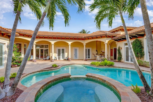 view of swimming pool with an in ground hot tub, french doors, and a patio area