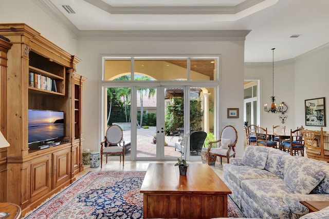 living room with crown molding, french doors, and a notable chandelier