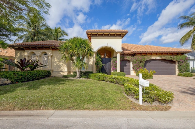 mediterranean / spanish house featuring a garage and a front yard