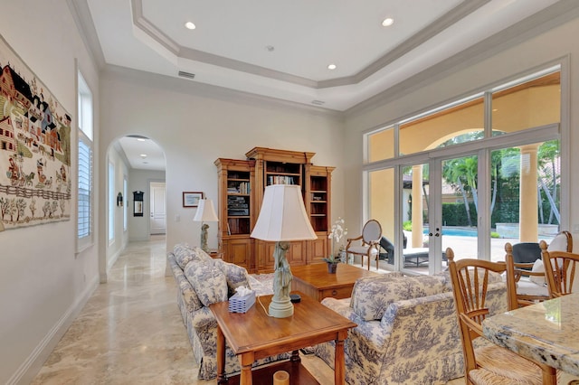 living room with french doors, a raised ceiling, plenty of natural light, and ornamental molding