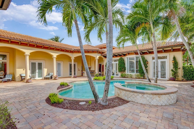 view of pool with a patio area, an in ground hot tub, and french doors