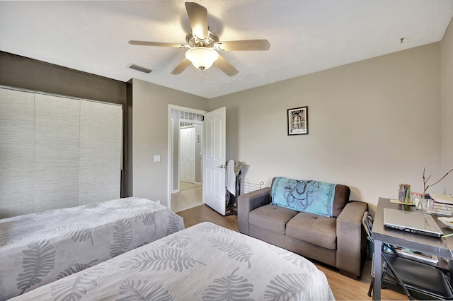 bedroom featuring ceiling fan, visible vents, and wood finished floors