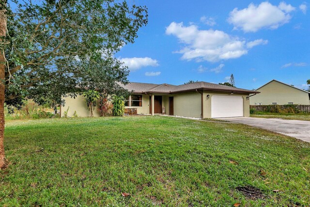 8865 SE May Ter, Hobe Sound, FL 33455 - ranch-style house with stucco siding, a garage, driveway, and a front yard