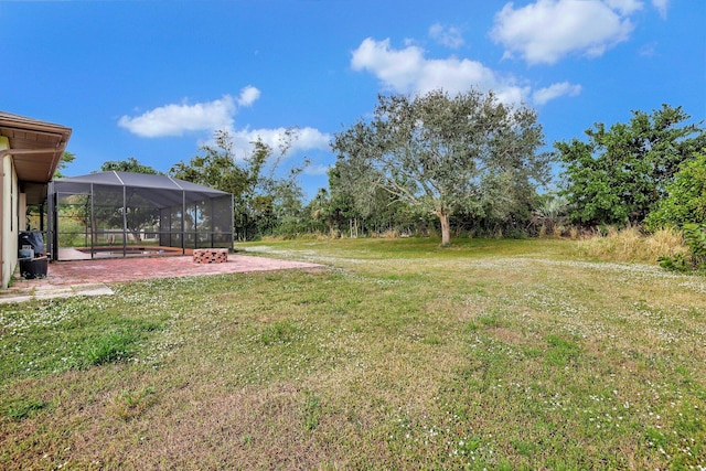 view of yard featuring glass enclosure and a patio