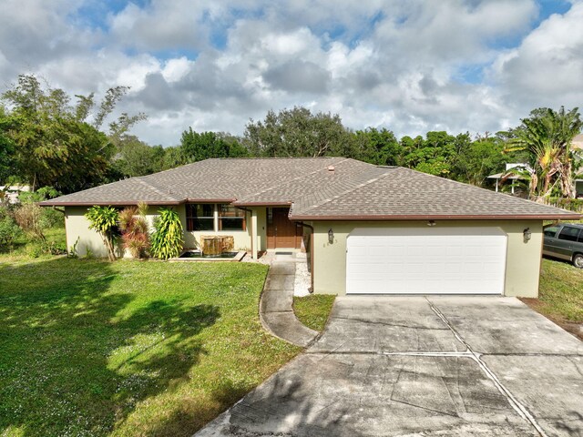 8865 SE May Ter, Hobe Sound, FL 33455 - single story home with stucco siding, driveway, an attached garage, a front lawn, and a shingled roof