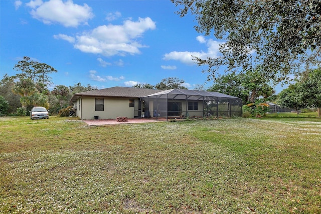 rear view of property featuring a patio, glass enclosure, a lawn, and a fire pit