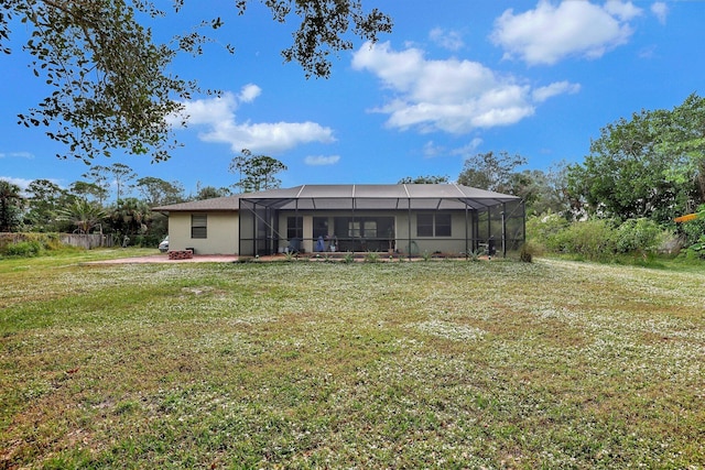 rear view of property featuring a lanai, a yard, a patio, and stucco siding