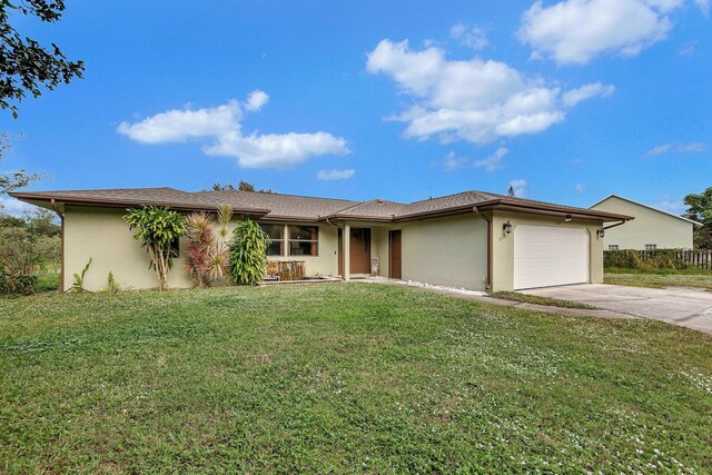 single story home featuring concrete driveway, a garage, a front yard, and stucco siding
