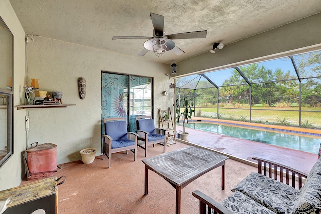 view of patio / terrace featuring glass enclosure, an outdoor pool, and ceiling fan