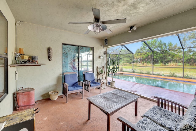 view of patio featuring a lanai, an outdoor pool, and a ceiling fan