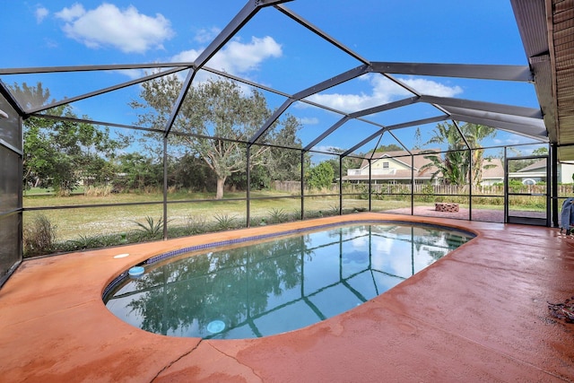 view of pool with a lawn, glass enclosure, and a patio area