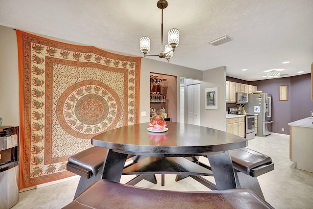 dining area featuring a textured ceiling and a notable chandelier