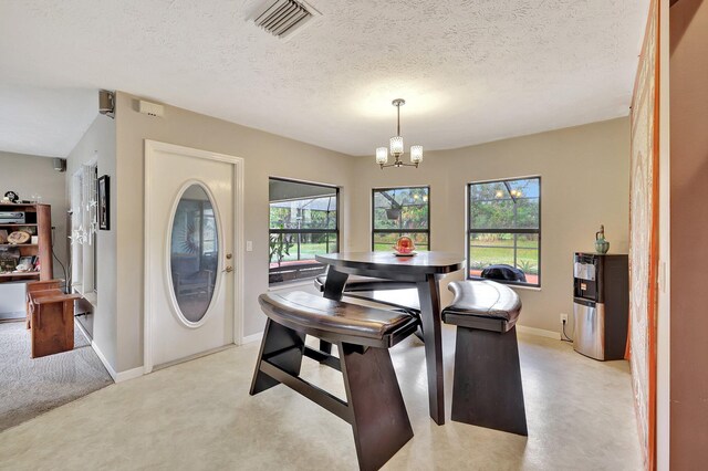 8865 SE May Ter, Hobe Sound, FL 33455 - dining area featuring a chandelier, baseboards, a textured ceiling, and light carpet