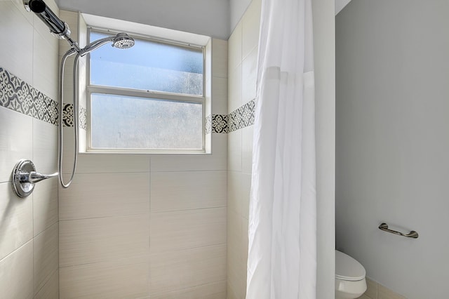 bathroom with a shower with curtain and toilet