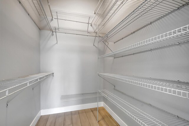 unfurnished bedroom with ceiling fan, vaulted ceiling, a closet, and light hardwood / wood-style flooring