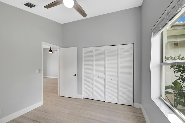 unfurnished bedroom with ceiling fan, light hardwood / wood-style floors, and a closet