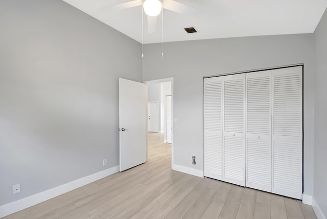 unfurnished bedroom featuring vaulted ceiling, light hardwood / wood-style floors, a closet, and ceiling fan