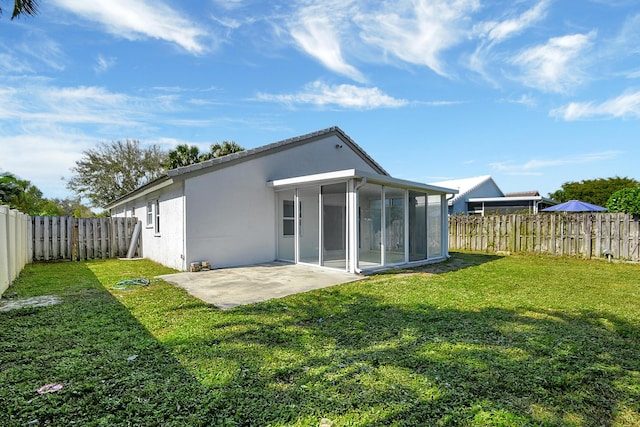 rear view of property featuring a patio, a sunroom, and a yard