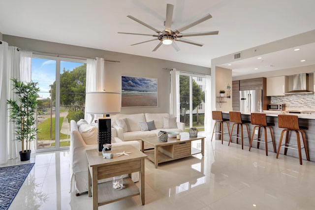 tiled living room featuring a wealth of natural light and ceiling fan